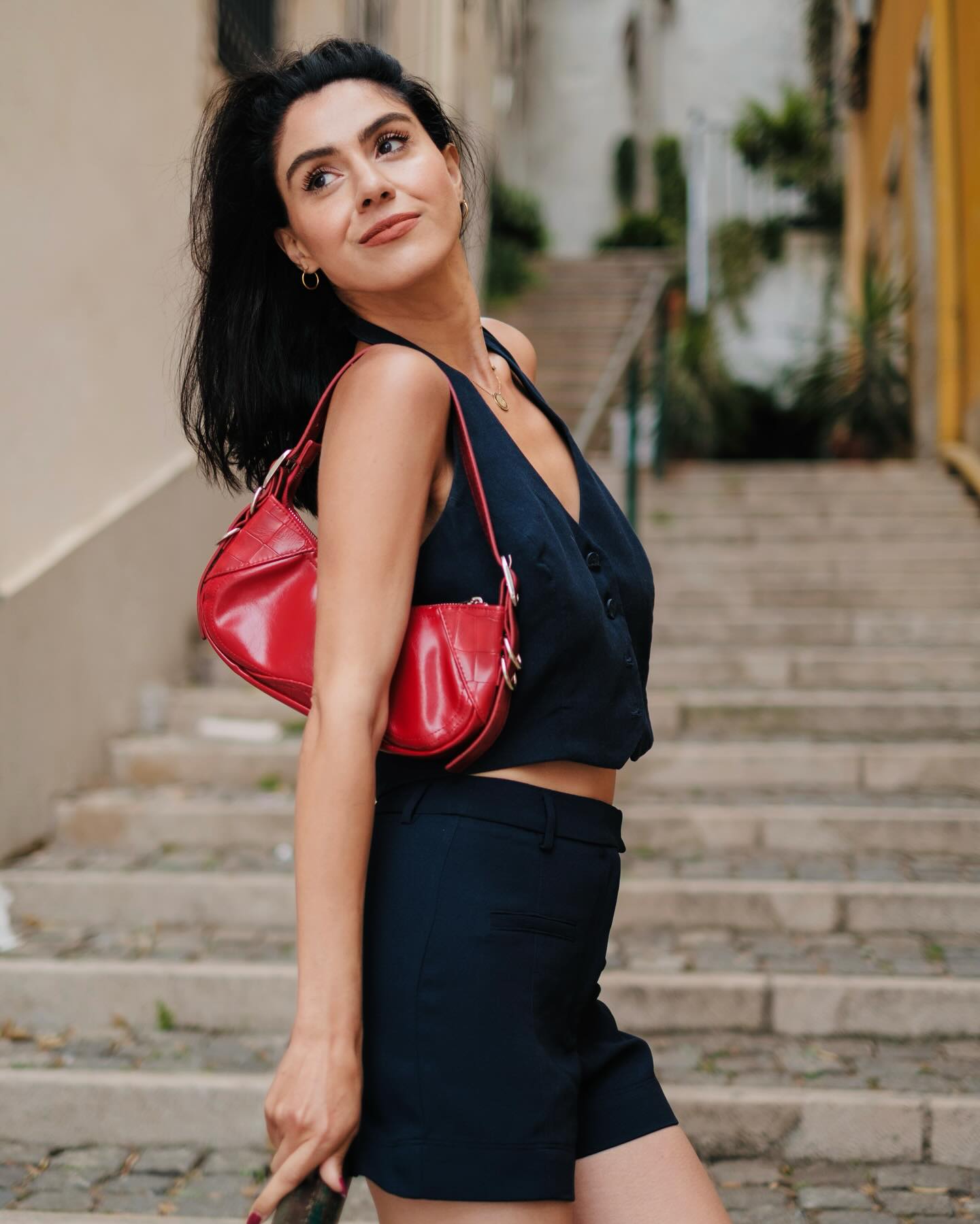 Kimia Kalbasi posing with a red bag on a Lisbon street