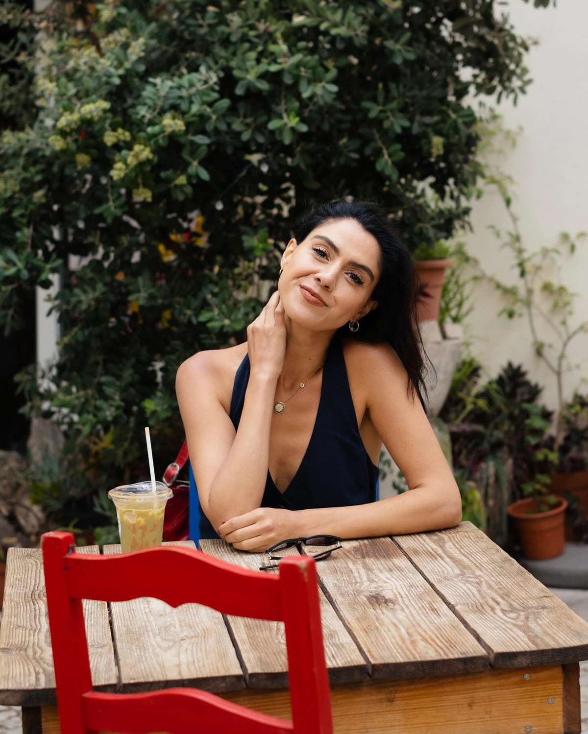 Kimia seated at an outdoor red table in Lisbon