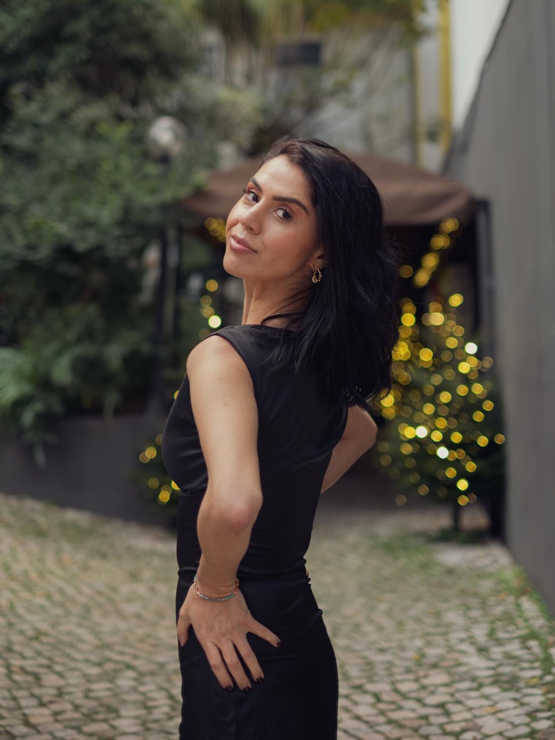Kimia turning toward the camera in a fitted black dress