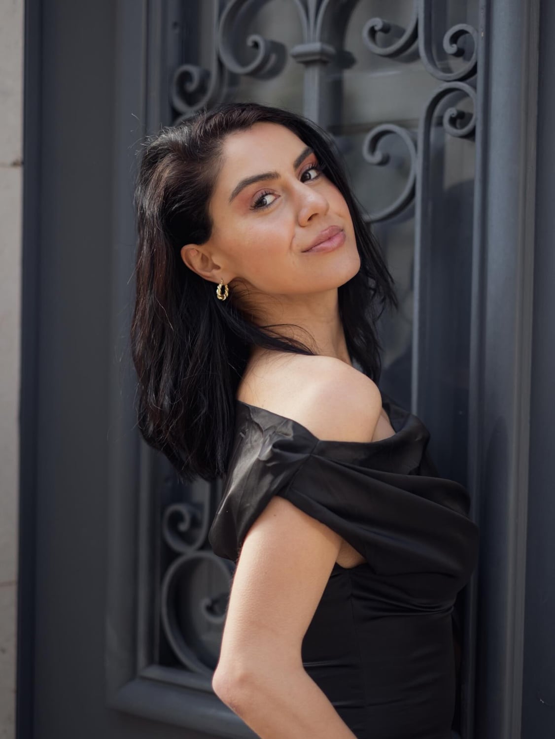 Close portrait of Kimia posed by a dark doorway