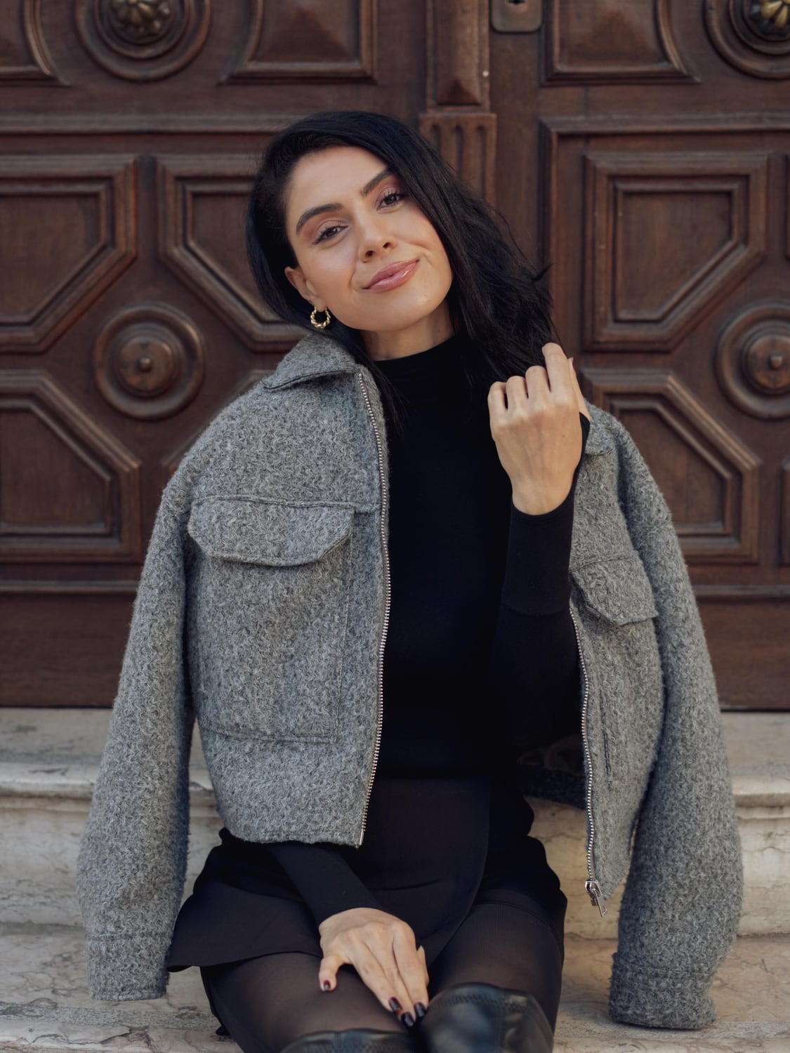 Kimia in a grey jacket posed against an ornate Lisbon doorway
